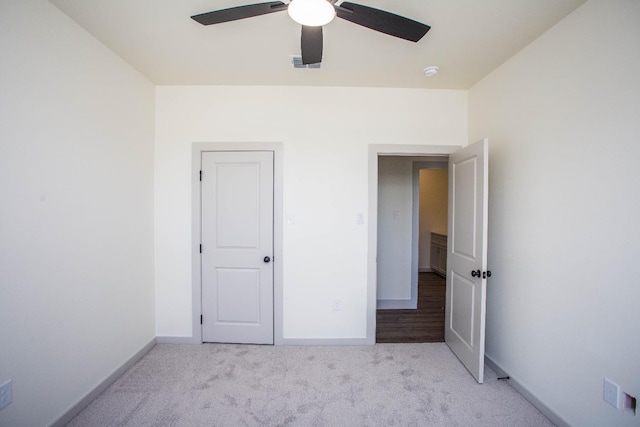 unfurnished bedroom with light colored carpet and ceiling fan