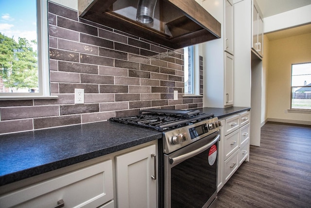 kitchen featuring plenty of natural light, stainless steel range with gas cooktop, white cabinets, and custom exhaust hood