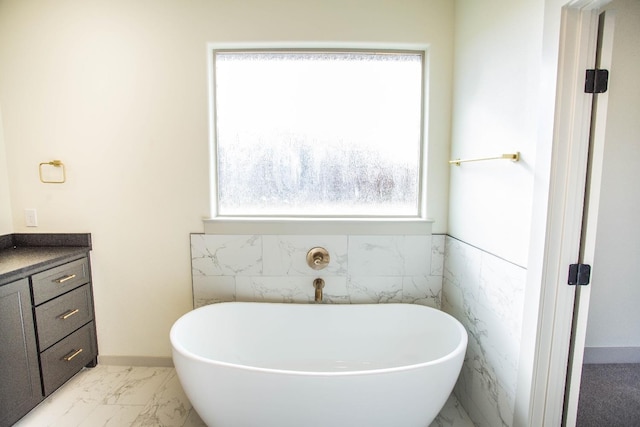 bathroom featuring vanity, a bath, and tile walls