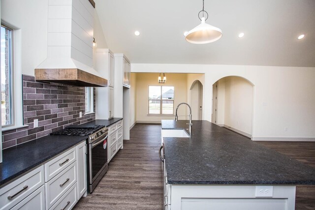 kitchen with pendant lighting, stainless steel range with gas cooktop, custom range hood, and white cabinets