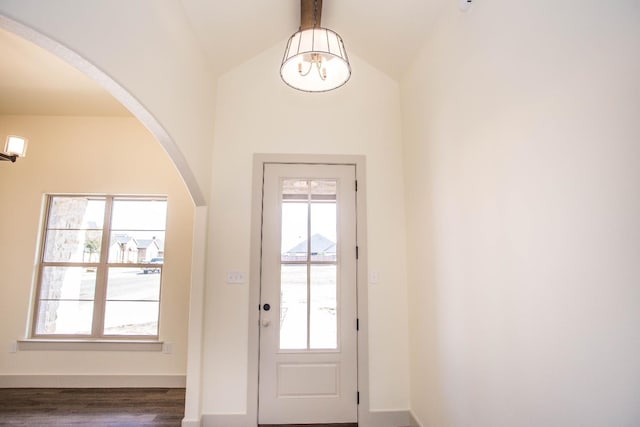 doorway to outside featuring plenty of natural light, dark hardwood / wood-style flooring, and vaulted ceiling