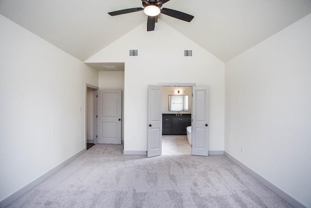 unfurnished bedroom featuring ceiling fan, connected bathroom, light carpet, and high vaulted ceiling