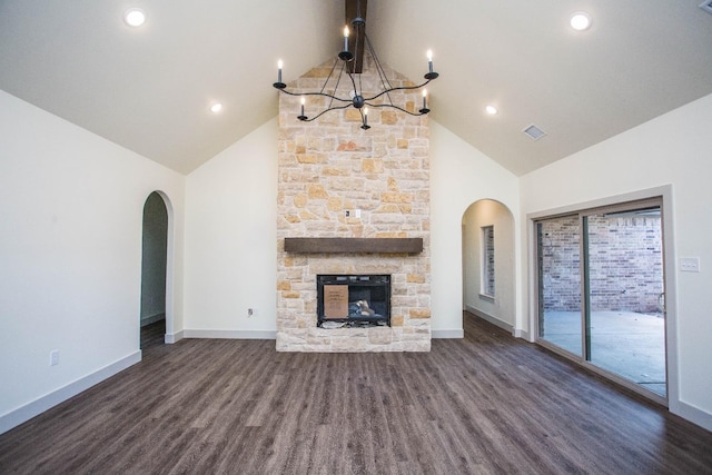 unfurnished living room with a stone fireplace, dark wood-type flooring, and high vaulted ceiling