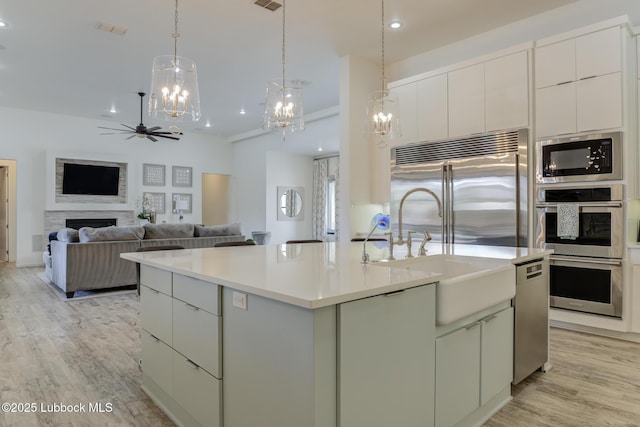 11604 Uxbridge Ave, Lubbock, TX 79424 - kitchen featuring stainless steel appliances, a ceiling fan, light wood-style flooring, a center island with sink, and recessed lighting
