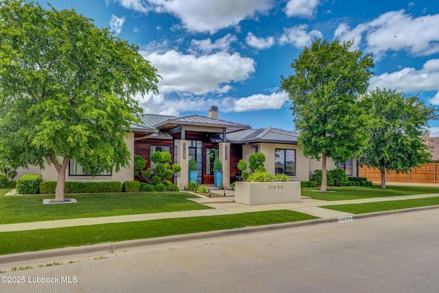 11604 Uxbridge Ave, Lubbock, TX 79424 - view of front of home featuring a standing seam roof, a metal roof, a chimney, and stucco siding