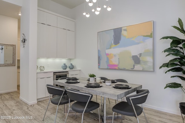11604 Uxbridge Ave, Lubbock, TX 79424 - dining room featuring light wood-type flooring, a fireplace, and wine cooler