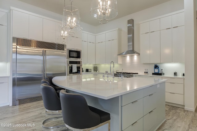 11604 Uxbridge Ave, Lubbock, TX 79424 - kitchen with built in appliances, wall chimney range hood, modern cabinets, and a chandelier