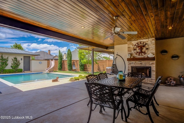 11604 Uxbridge Ave, Lubbock, TX 79424 - view of patio / terrace with an outdoor stone fireplace, a ceiling fan, and outdoor dining space