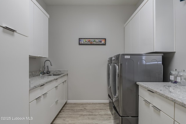 11604 Uxbridge Ave, Lubbock, TX 79424 - washroom featuring cabinet space, washing machine and dryer, and light wood-type flooring