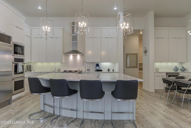 11604 Uxbridge Ave, Lubbock, TX 79424 - kitchen featuring modern cabinets, built in appliances, a chandelier, wall chimney exhaust hood, and backsplash