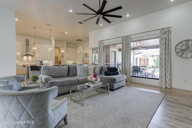 11604 Uxbridge Ave, Lubbock, TX 79424 - living room with light wood-type flooring, ceiling fan, a chandelier, and recessed lighting