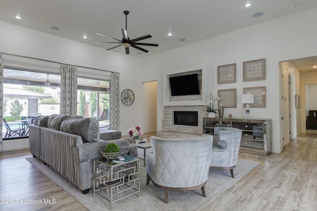 11604 Uxbridge Ave, Lubbock, TX 79424 - living room with light wood-style flooring, ceiling fan, a glass covered fireplace, and recessed lighting