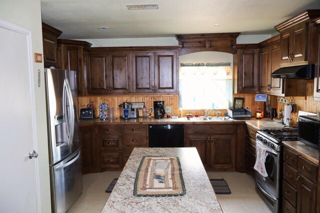 kitchen featuring tasteful backsplash, dark brown cabinetry, stainless steel appliances, and sink