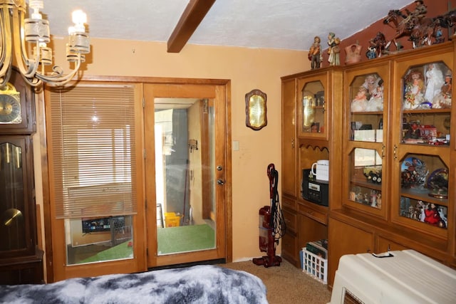 doorway with beam ceiling, carpet, and a chandelier