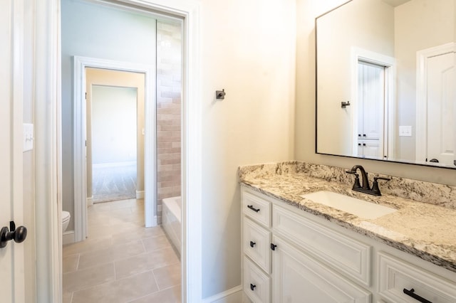 bathroom with vanity, a bath, tile patterned floors, and toilet