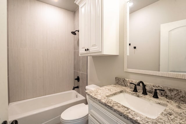 full bathroom with vanity, tiled shower / bath, and toilet