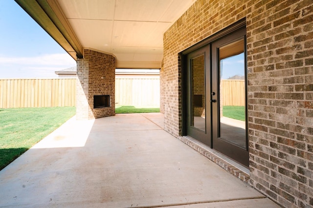 view of patio featuring an outdoor brick fireplace and french doors