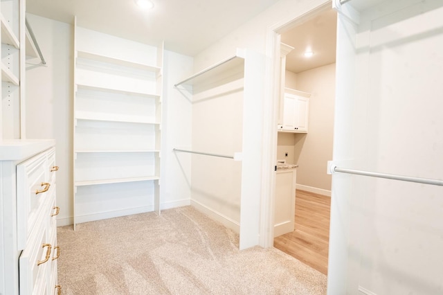 walk in closet featuring light carpet