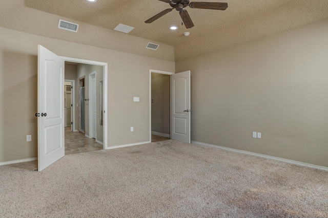 unfurnished bedroom with light carpet, a textured ceiling, and ceiling fan