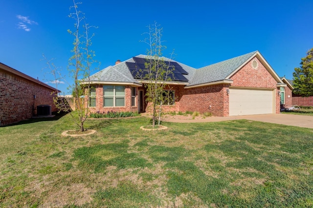 view of front facade with a front yard, central AC unit, and solar panels