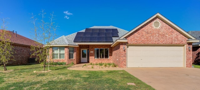 view of front of house featuring a garage, central AC, a front yard, and solar panels