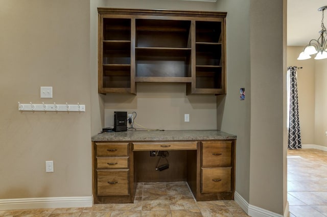 kitchen featuring hanging light fixtures, built in desk, and a chandelier