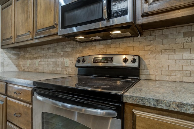 kitchen with appliances with stainless steel finishes and backsplash