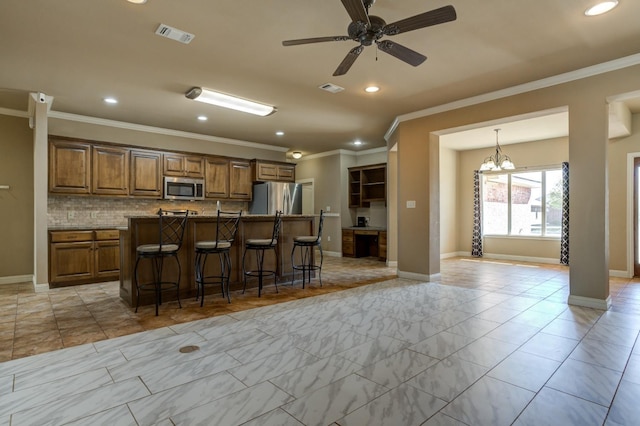 kitchen with a kitchen bar, appliances with stainless steel finishes, a kitchen island, pendant lighting, and decorative backsplash