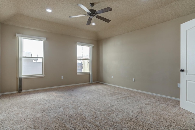 unfurnished room featuring ceiling fan, light carpet, and a textured ceiling