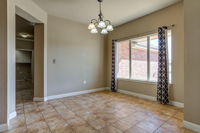 tiled spare room featuring an inviting chandelier and a wealth of natural light