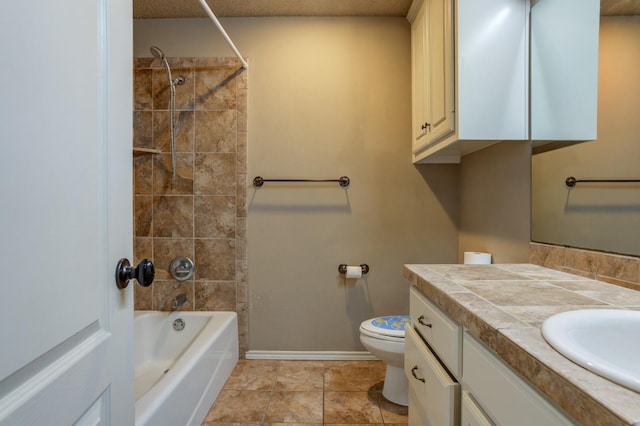 full bathroom featuring vanity, tiled shower / bath, and toilet