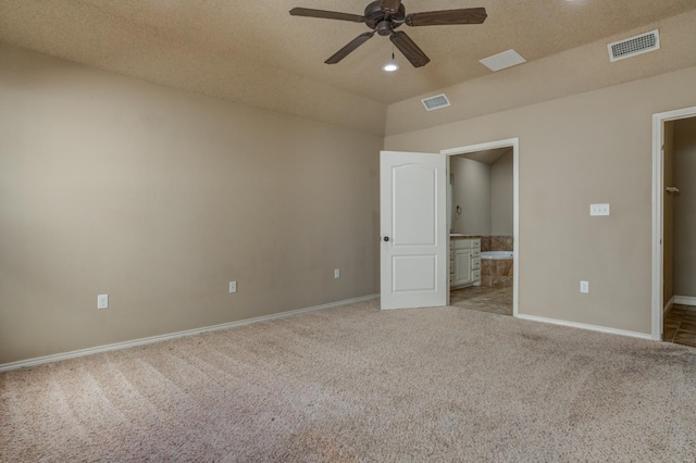 unfurnished bedroom with ensuite bathroom, light carpet, a textured ceiling, and ceiling fan