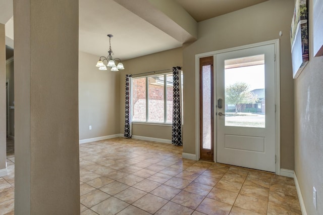 foyer with plenty of natural light, light tile patterned floors, and a notable chandelier