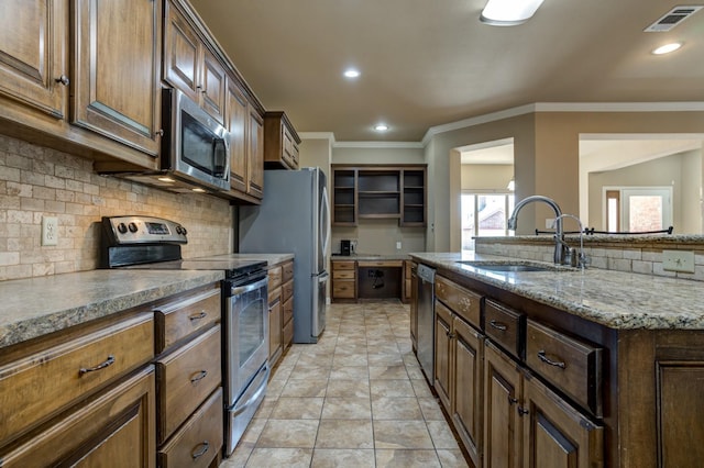 kitchen featuring sink, stainless steel appliances, ornamental molding, light stone countertops, and decorative backsplash