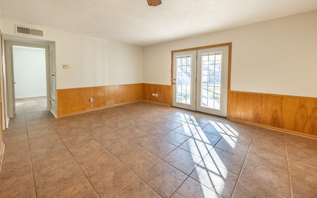 empty room featuring light tile patterned flooring and a textured ceiling