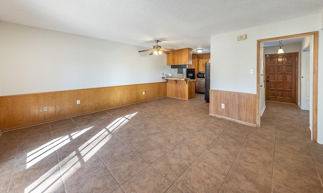 kitchen with ceiling fan, kitchen peninsula, a textured ceiling, and black appliances