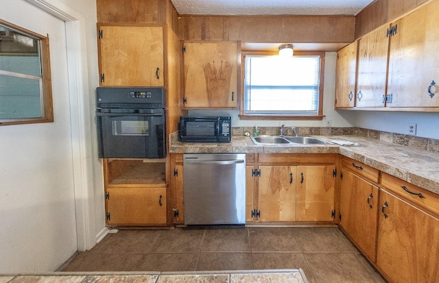 kitchen with sink, dark tile patterned flooring, and black appliances