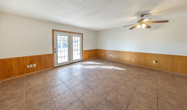 empty room featuring ceiling fan, tile patterned floors, and a textured ceiling