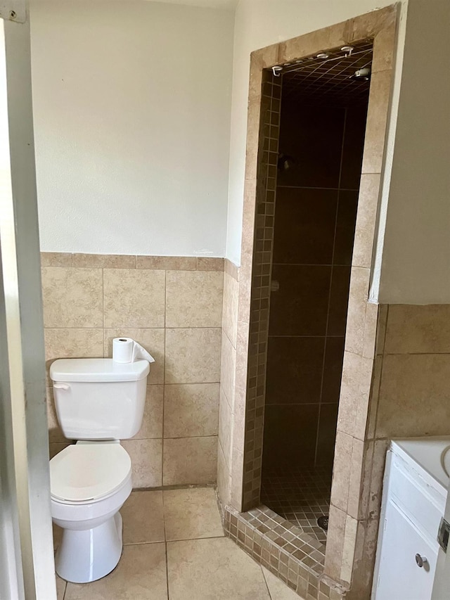 bathroom with a tile shower, tile walls, tile patterned floors, and toilet