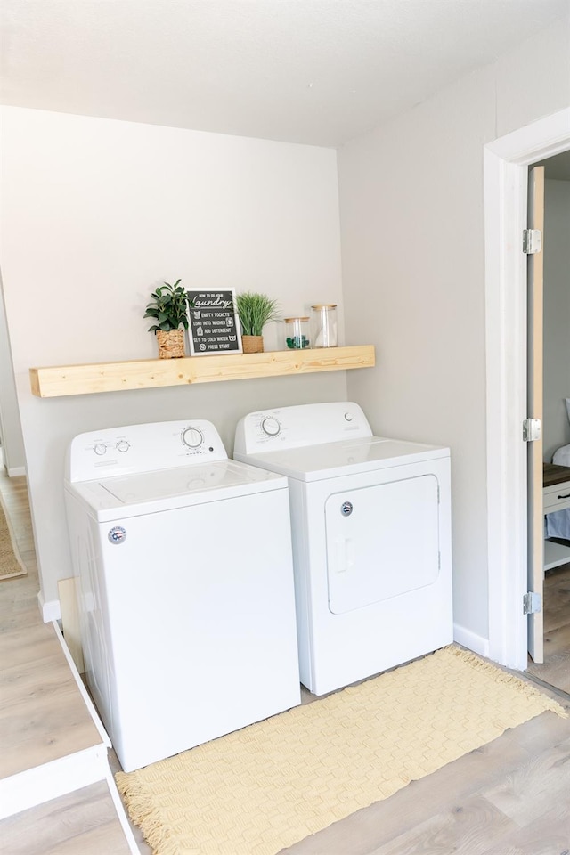 laundry area with wood-type flooring and washer and clothes dryer