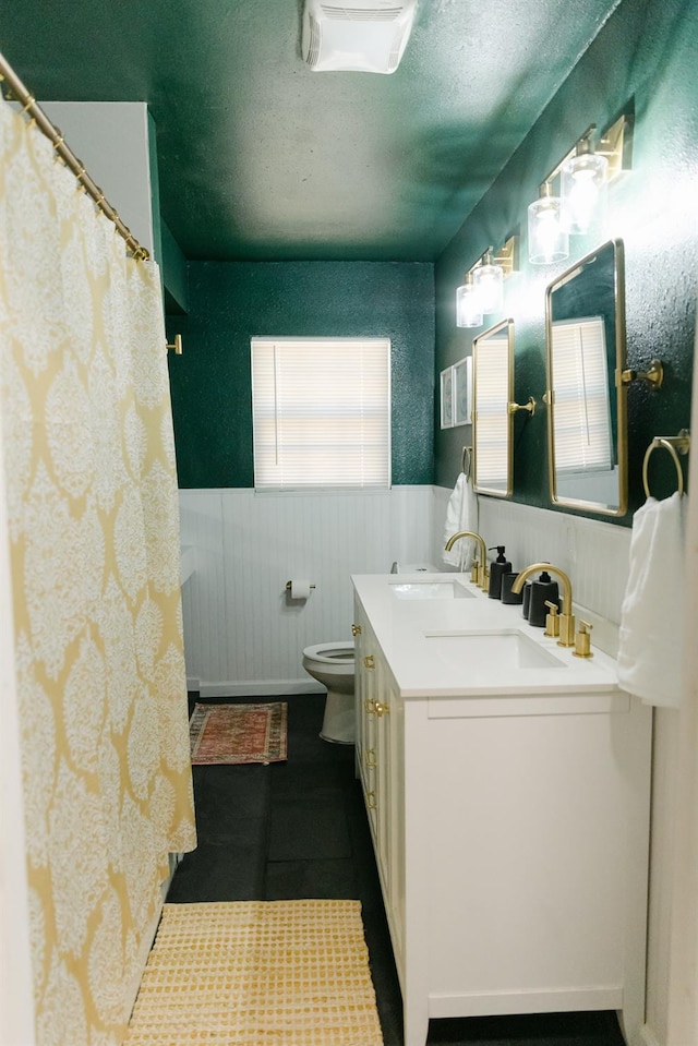 bathroom with vanity, toilet, and a textured ceiling