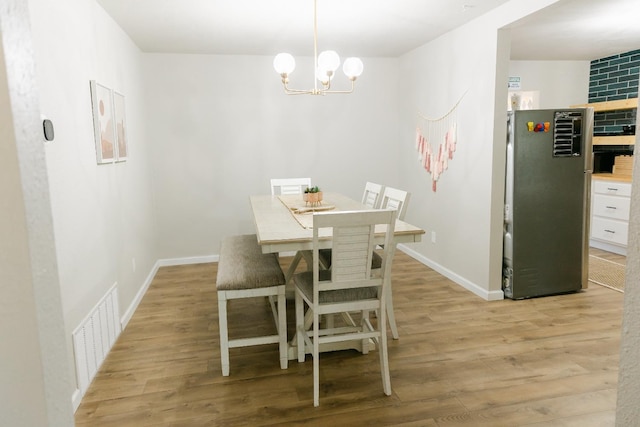 dining area featuring a notable chandelier and light hardwood / wood-style floors