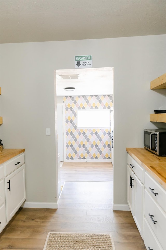 kitchen featuring white cabinetry, wood counters, and light hardwood / wood-style floors