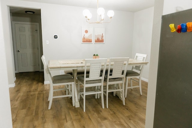 dining area with an inviting chandelier and wood-type flooring