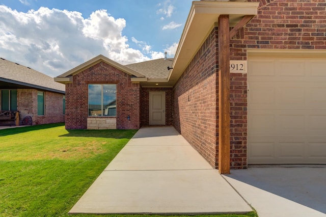 doorway to property with a garage and a lawn