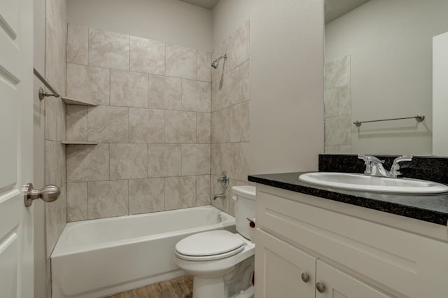 full bathroom featuring tiled shower / bath, vanity, toilet, and wood-type flooring