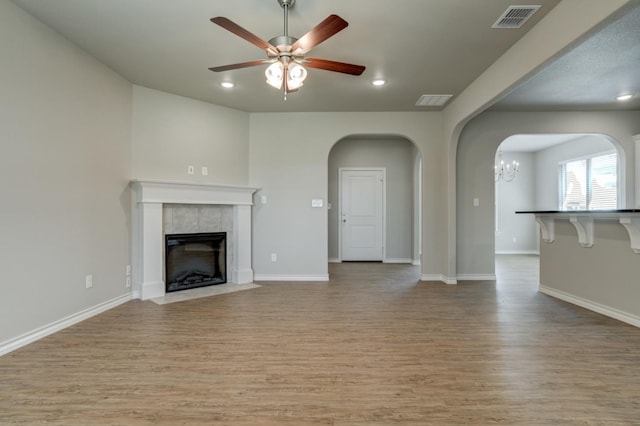 unfurnished living room with a fireplace, light hardwood / wood-style floors, and ceiling fan