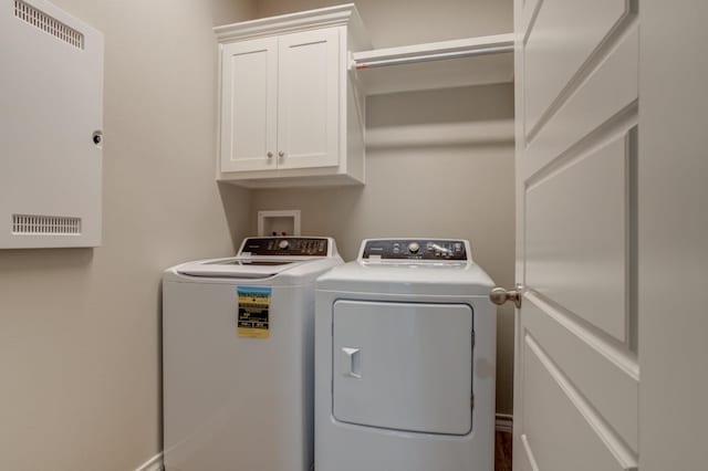 clothes washing area with cabinets and independent washer and dryer