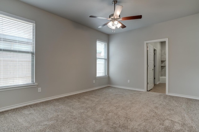 carpeted spare room with ceiling fan