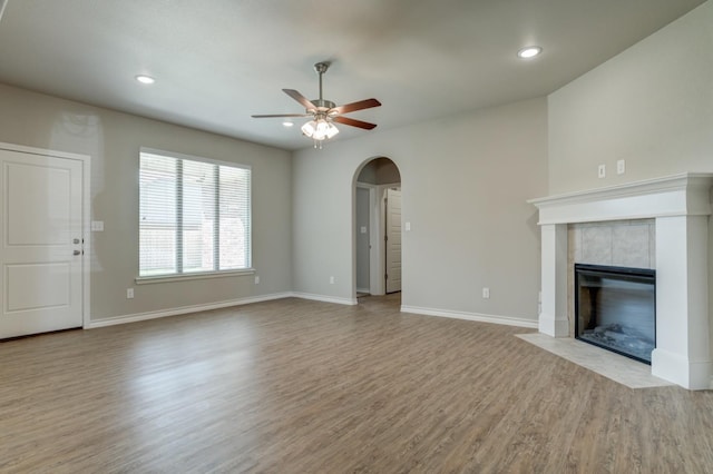 unfurnished living room featuring a fireplace, light hardwood / wood-style flooring, and ceiling fan